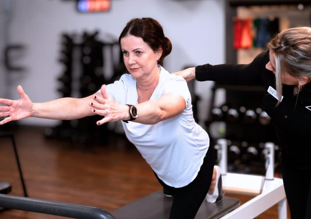 Exercise Physiologist supporting a woman with safe strength training at Forge West End Brisbane Women's Health Clinic.