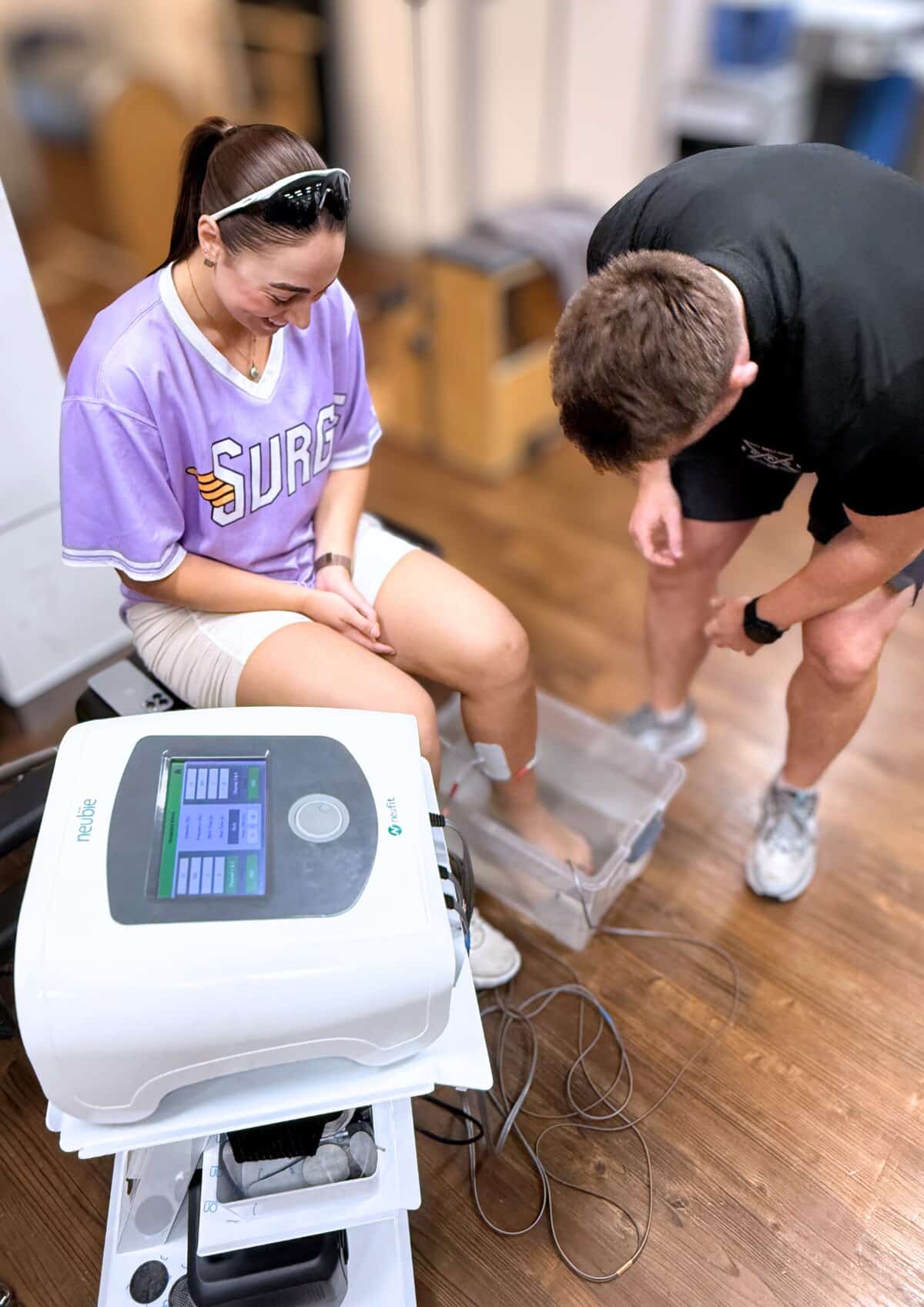 Neubie device in use during a physiotherapy session at Forge West End, Brisbane, with the physiotherapist attending to the patient